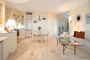 A modern kitchen with a dining area, a glass coffee table, and a sofa with a cushion. - Villa Luciva by Klodge - Pool escape in San Teodoro (San Teodoro)