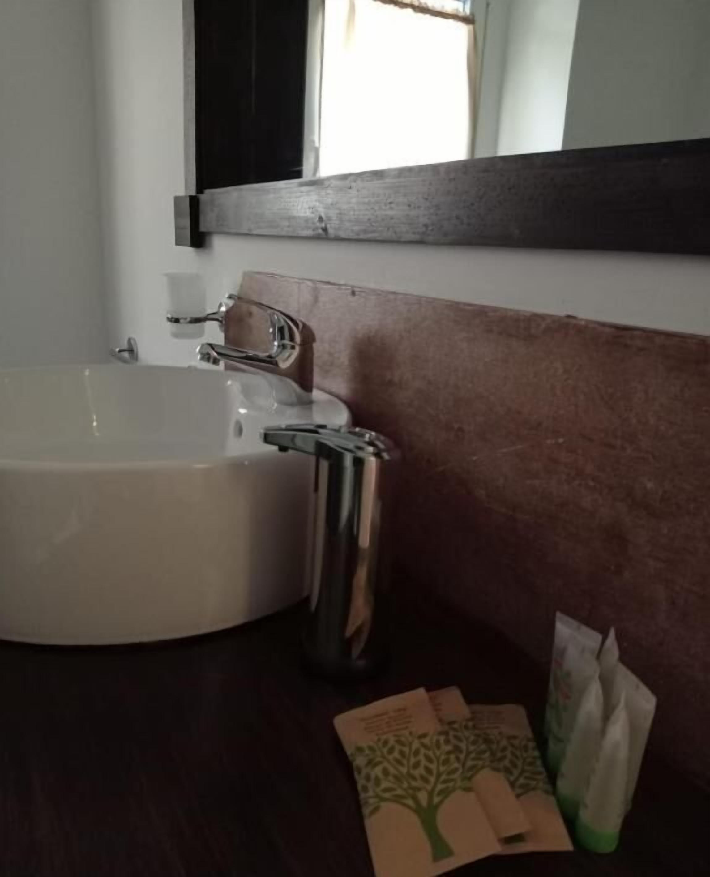 Une salle de bain avec un lavabo blanc, un miroir et un porte-serviettes.