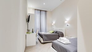 Een moderne hotelkamer met een bed, nachtkastje en een bureau met stoel.