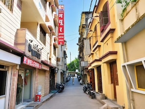 A narrow street with buildings on either side, a visible hotel sign, and parked motorcycles. - Hotel Green Gwalior (Gwalior)