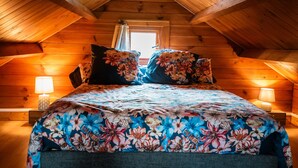 A wooden cabin bedroom with a bed, pillows, and a window. - Guest Room - Chalet in Pays d'Auge with Garden (Lessard-et-le-Chêne)