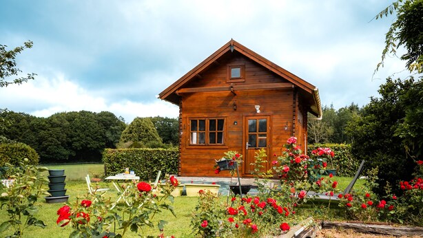 A wooden cabin with a pitched roof, surrounded by a garden with red roses. - Guest Room - Chalet in Pays d'Auge with Garden (Lessard-et-le-Chêne)
