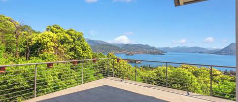 A balcony with a view of a lake and mountains.