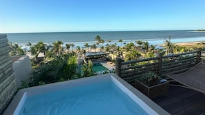 A pool area with a view of the beach and ocean.
