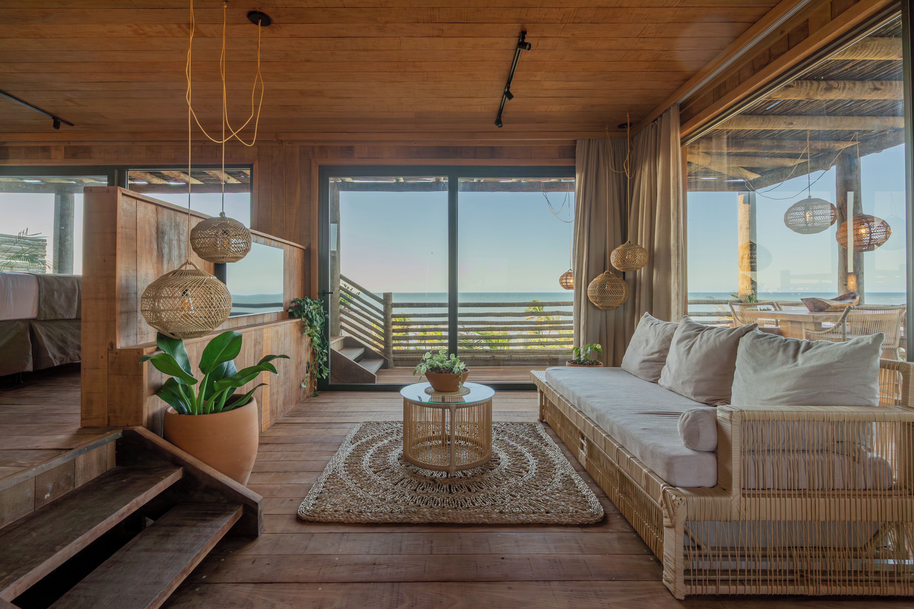 Un interior de madera con un sofá, una mesa de centro y vistas al mar.
