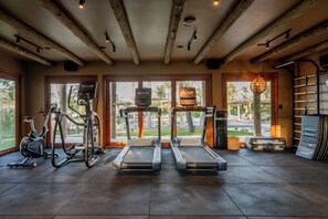 Un gimnasio con cintas de correr, bicicletas estáticas y equipo de ejercicio.