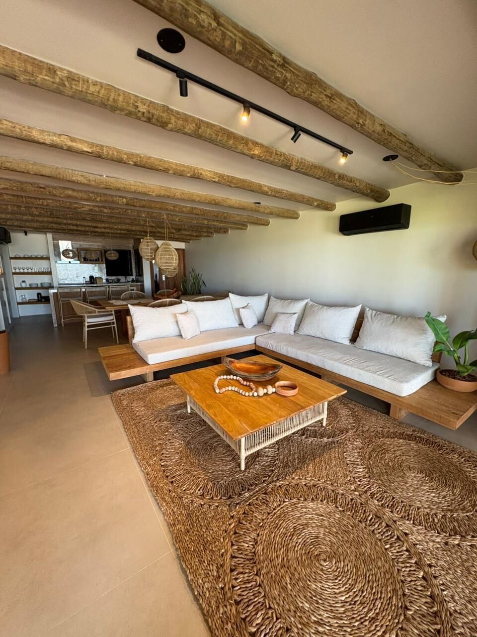 A modern living room with a large L-shaped sofa, a wooden coffee table, and a woven rug.
