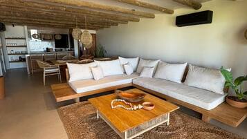 A modern living room with a large L-shaped sofa, a wooden coffee table, and a woven rug.