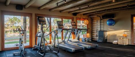 A gym with treadmills, stationary bikes, and elliptical machines.