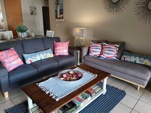 Un salon avec deux canapés, une table basse et une lampe.