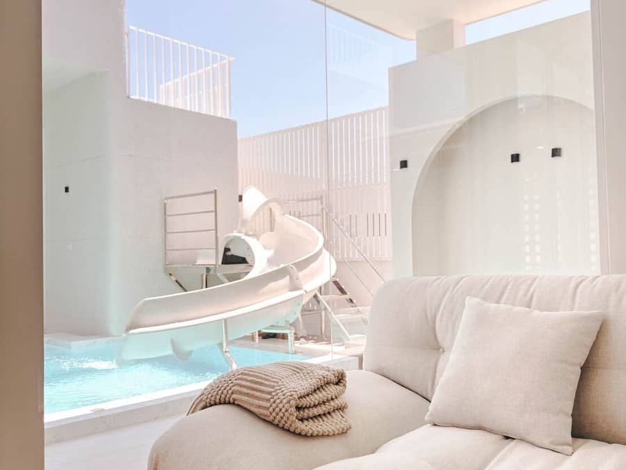 A modern interior with a sofa, a pool, and a slide.