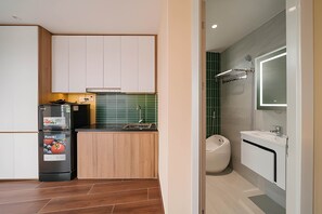 Suíte, sacada | Cozinha privada | Geladeira, cooktop