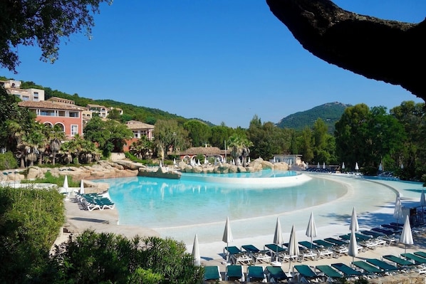 Ein Resort mit großem Pool, Liegestühlen und einem Bergpanorama.