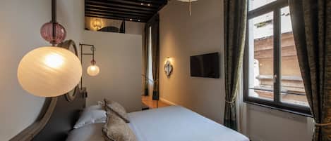 Hotelkamer met een bed, nachtlampjes, een flatscreen televisie en uitzicht door het raam.