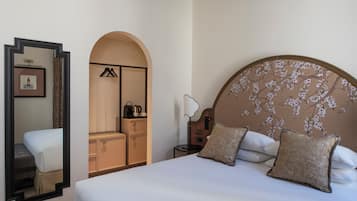 Ein Hotelzimmer mit einem großen Bett, einem Kleiderschrank, einem Spiegel und einem Nachttisch.