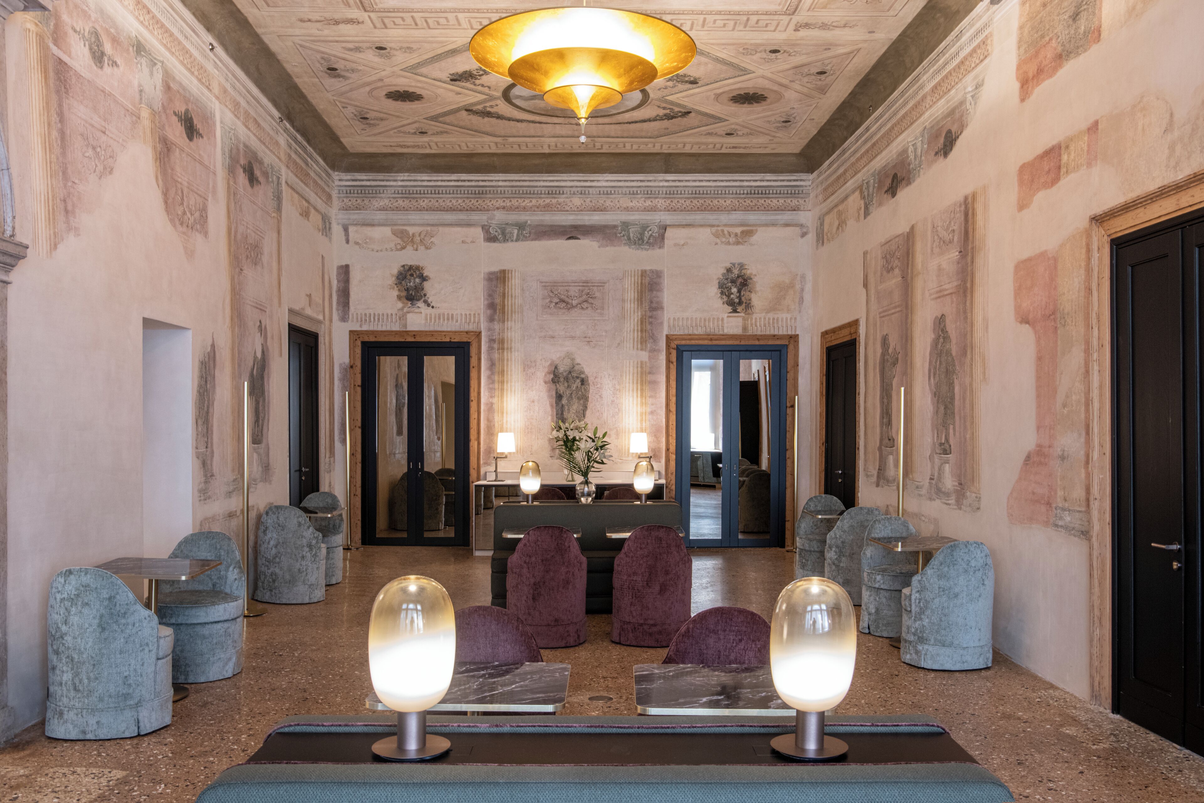 A lobby with a marble floor, a reception desk, and a chandelier.