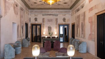 A lobby with a marble floor, a reception desk, and a chandelier.