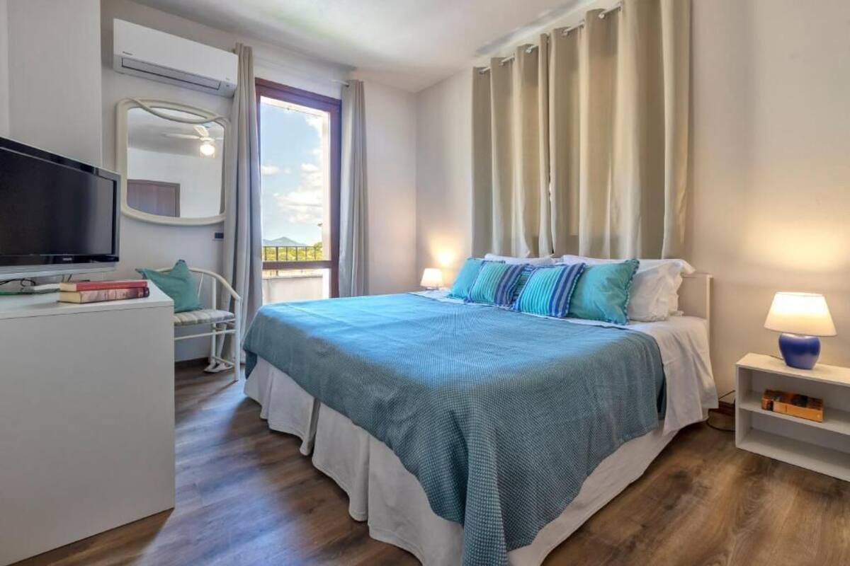 Una camera da letto con un letto, una TV, una sedia, una scrivania e una finestra.