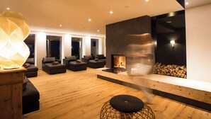 Ein modernes Wohnzimmer mit Kamin, Sofas und Holzboden.