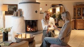 Ein gemütliches Wohnzimmer mit Kamin, Sitzgelegenheiten und einem Bücherregal.