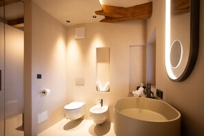 A modern bathroom with a large bathtub, a toilet, and a sink.