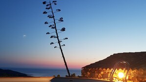 Un barco atracado en un muelle con un atardecer de fondo.
