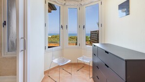 Ein Zimmer mit Meerblick, einem Schrank und zwei Stühlen.