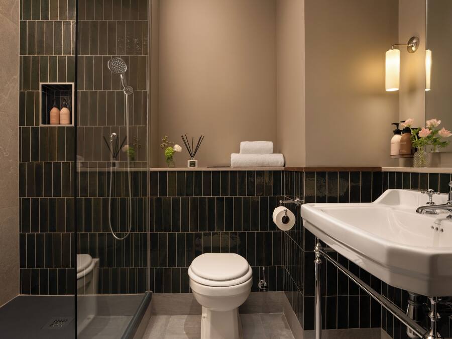 A modern bathroom with a shower, toilet, and sink.