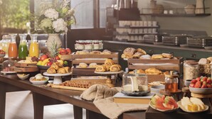 A breakfast buffet with various food items and a vase of flowers. - The Grace Wesport Estate  (Westport)