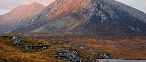 Paesaggio montuoso con uno specchio d'acqua in primo piano.