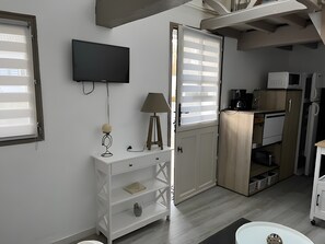A compact kitchen with a TV, a lamp, and a cabinet. - Gîte “Le Bois Flotté” in Nature with Wi-Fi (Boismont)