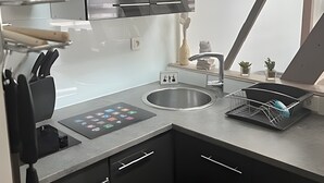 Una cucina moderna con lavello in acciaio inossidabile, forno integrato e pannello di controllo digitale.