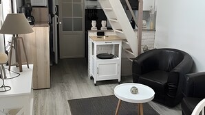 Un interno moderno con una scala, un'area pranzo con tavolo e sedie, e un angolo cucina.