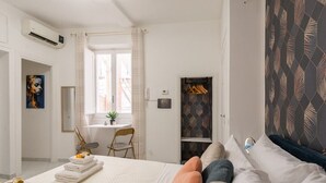 A hotel room with a bed, a window, a desk, a chair, and a wardrobe. - Adorable 1-bedroom apartment with AC in charming Roma (Roma)