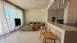 Ein modernes Wohnzimmer mit einer Couch, einem Hocker und Barhocker.