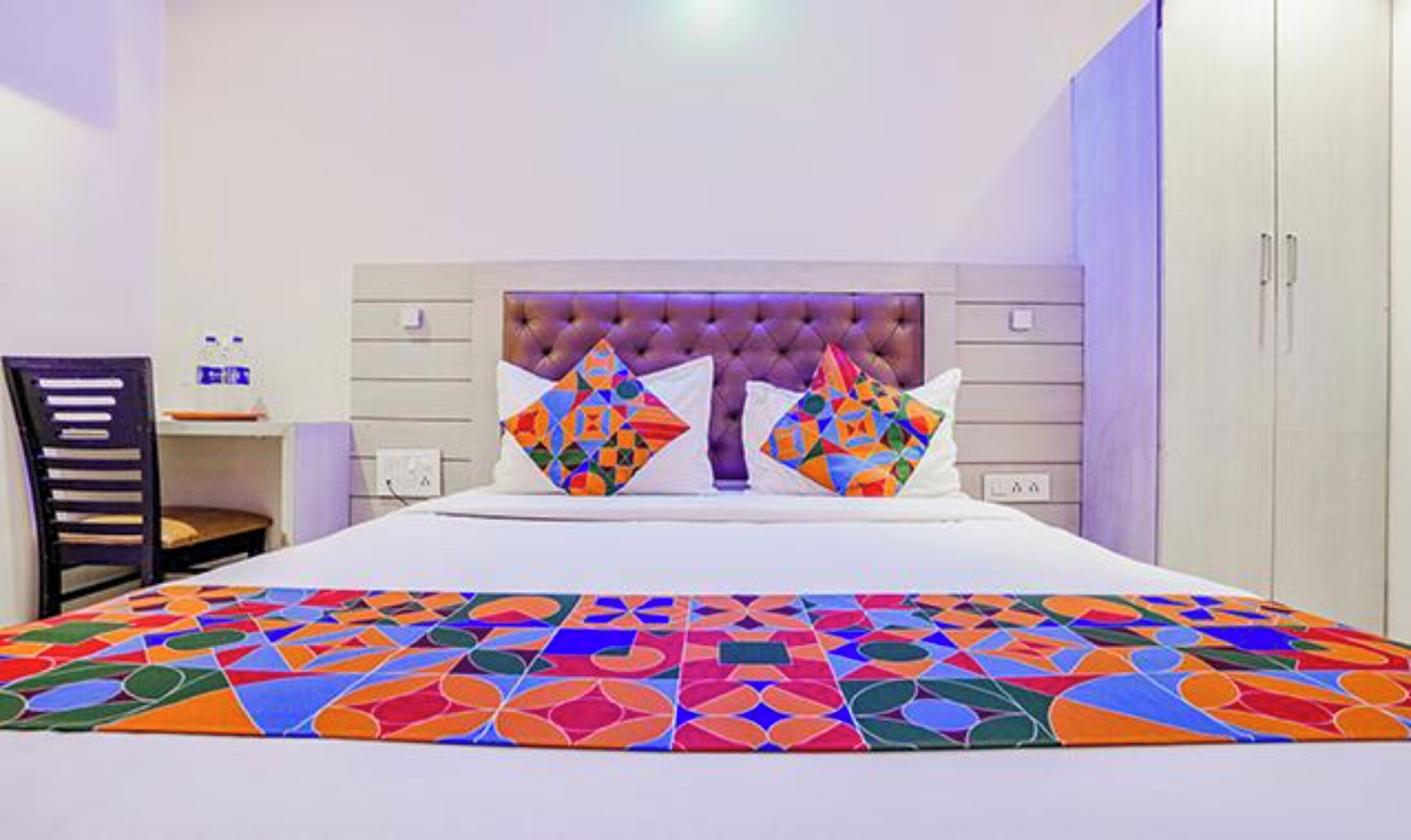 Une chambre d’hôtel avec un lit, un bureau et une chaise.