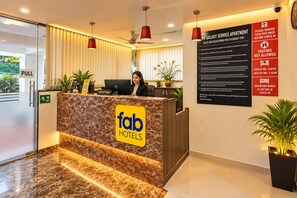A reception desk with a marble top, a sign for 'fab hotels,' and a 'pull' sign on the left. - FabHotel Galaxy Apartment (Pune)