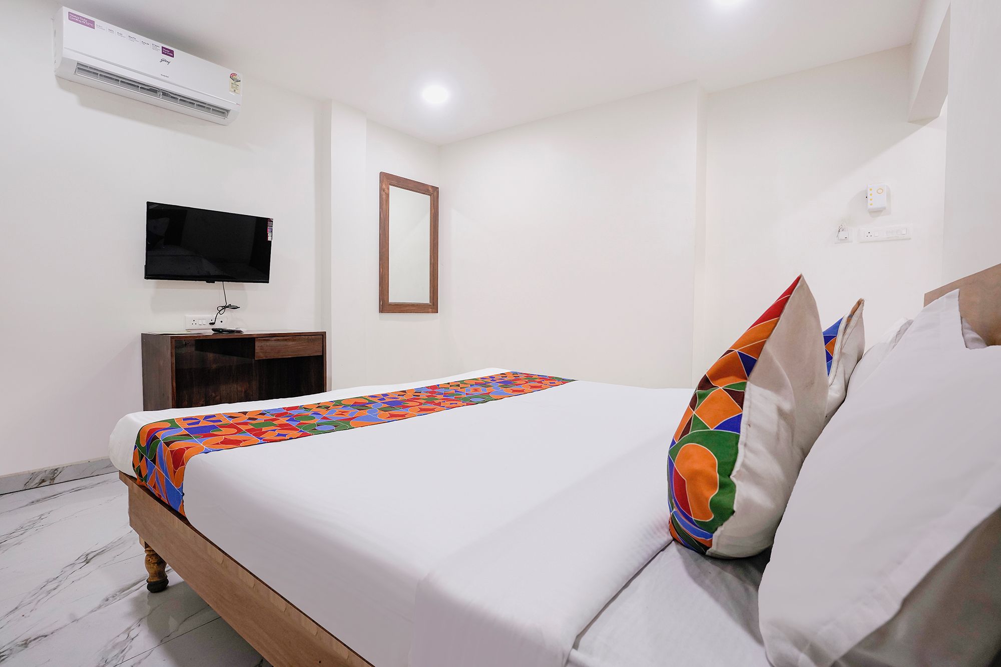 Une chambre d’hôtel équipée d’un lit, d’une télévision, d’un bureau et d’un appareil de climatisation.