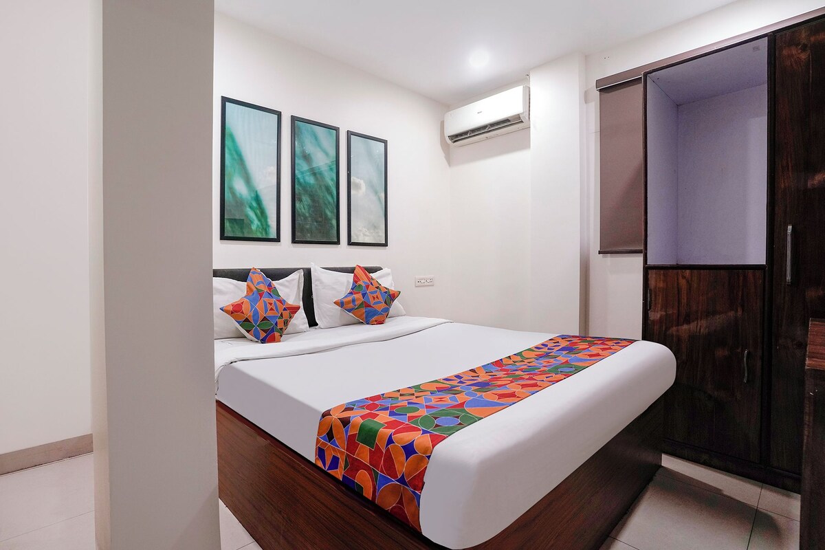Habitación de hotel con cama, armario y aire acondicionado de pared.