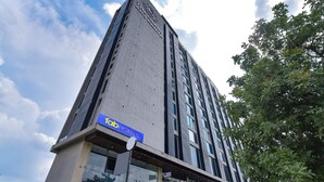 Un edificio alto de diseño moderno, con un llamativo rótulo de 'fab hotels' en la parte inferior.