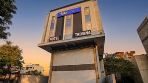 Un edificio moderno con un cartel que dice 'fabHOTELS TRIVANA HOTEL'.