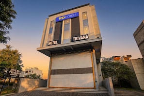 Un edificio moderno con un cartello che riporta la scritta 'fabHOTELS TRIVANA HOTEL'.