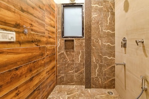 A bathroom with wooden paneling, a mirror, marble tiles, and a shower with a handheld showerhead. - FabHotel Harsh Paradise - Malviya Nagar (Jaipur)