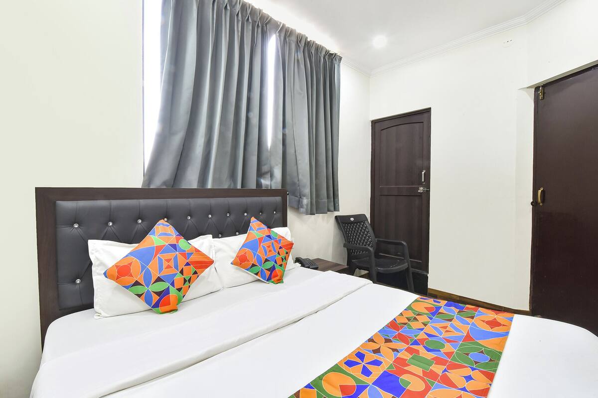 Ein Hotelzimmer mit Bett, Stuhl, Schreibtisch und Kleiderschrank.
