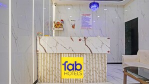 Ein Hotelrezeptionstresen mit Marmorplatte und einem Schild mit der Aufschrift 'fab hotels'.