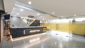 A hotel reception area with a marble counter, a clock, and a sign reading 'RECEPTION.' - FabHotel D Crown - Nr Ashok Vihar (New Delhi)
