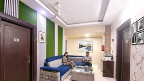 Un hall d’entrée moderne avec un canapé bleu, un comptoir de réception et un ventilateur de plafond.