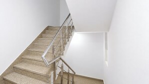 Un escalier avec des rampes en métal et un mur uni.