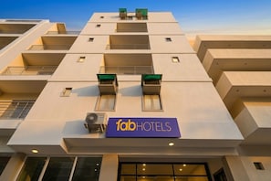 Un edifici modern amb façana plana, múltiples balcons i un rètol que diu 'fabHOTELS'.