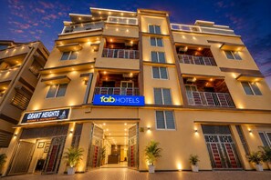 A multi-story hotel with a prominent 'fab hotels' sign, a 'Grant Heights' sign, and a reception area with potted plants. - Fabhotel Grant Heights - Nr. Biju Patnaik International Airport (Bhubaneshwar)
